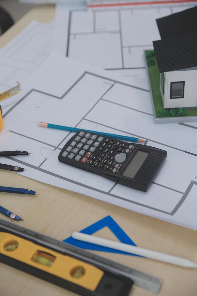 A table with a calculator, pencils, and other tools photo