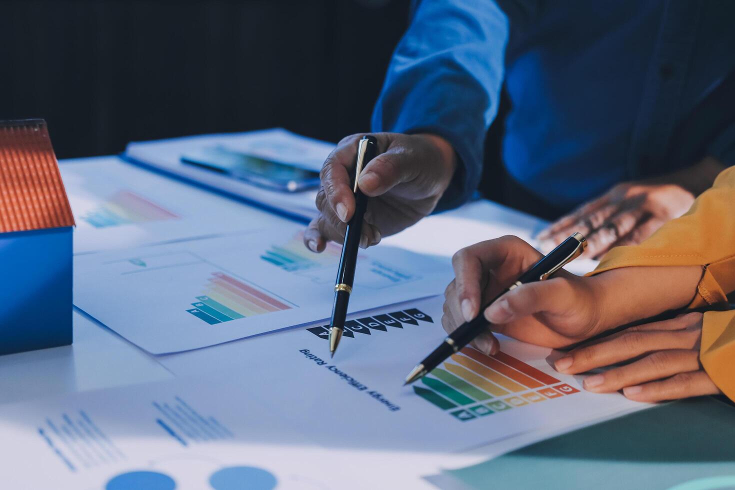 Business people working on a project with graphs and papers photo