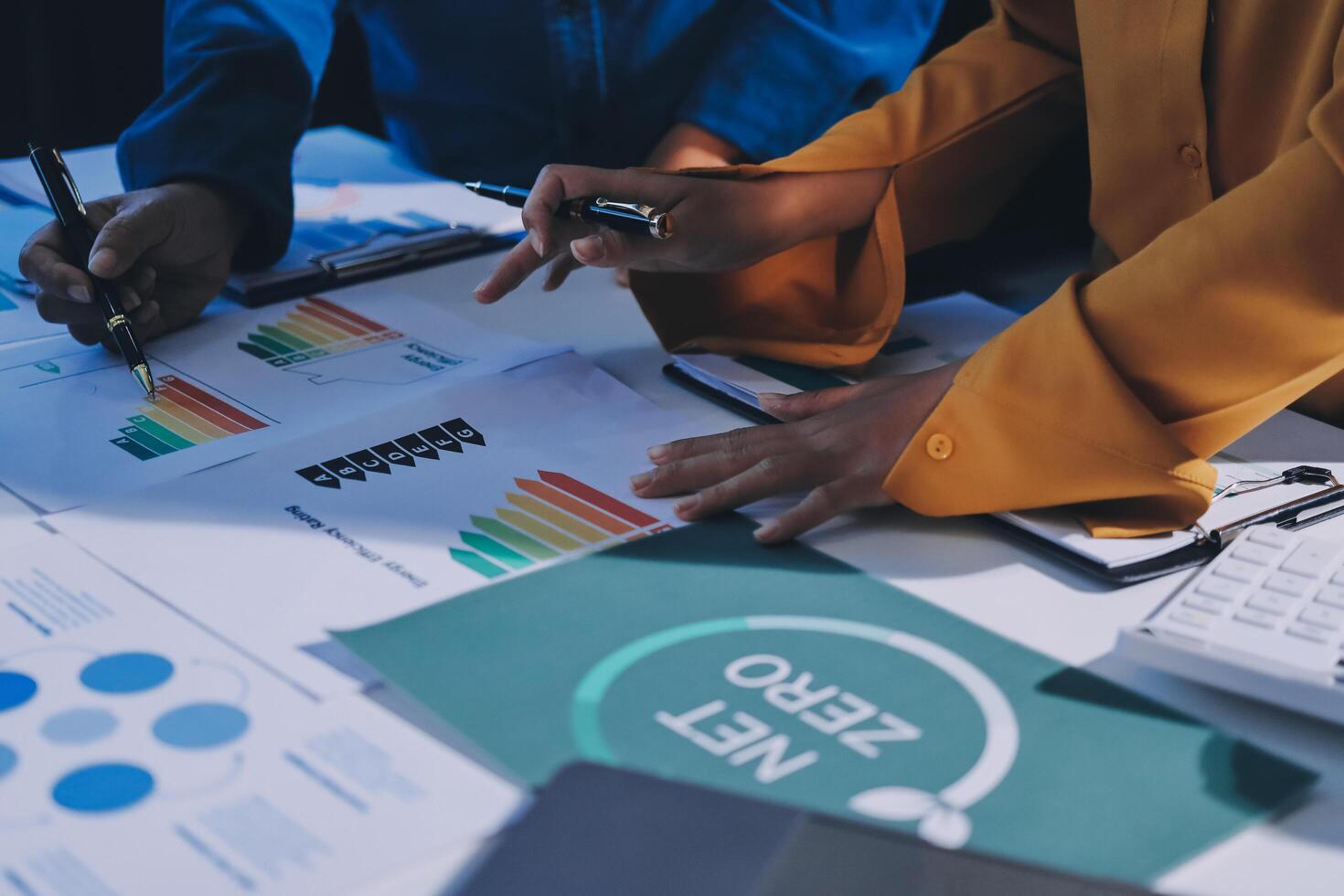 Business people working on a project with graphs and papers photo