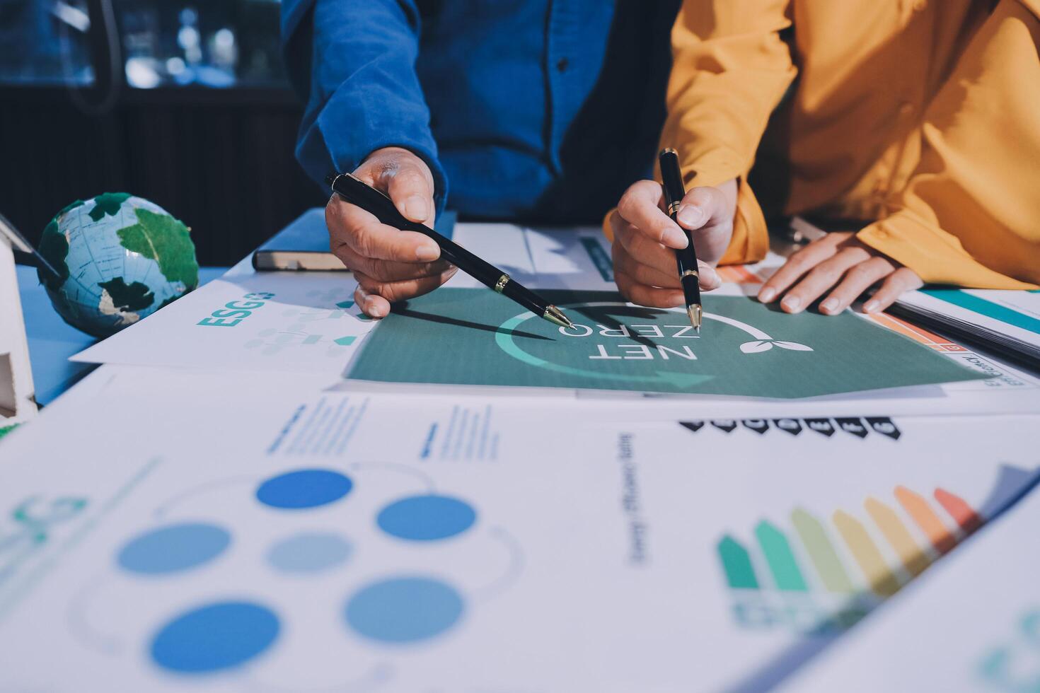 Business people working on a project with graphs and papers photo