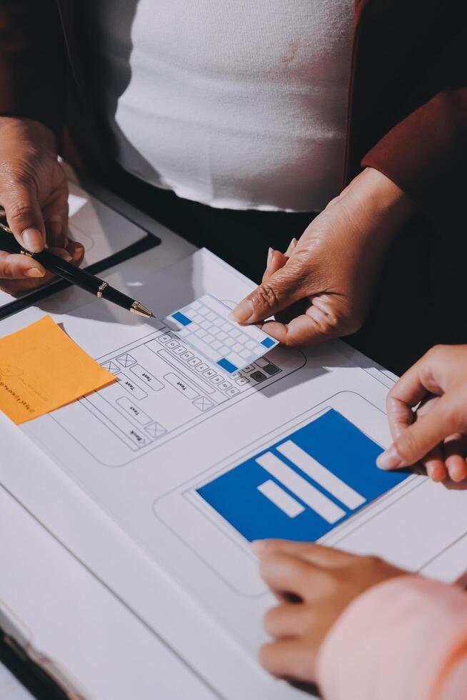 A group of people working on a project with a laptop and paper photo