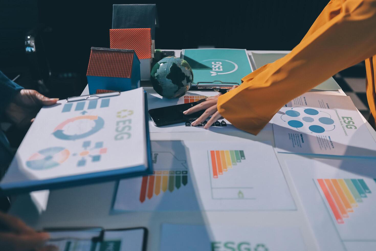 Business people working on a table with graphs and papers photo