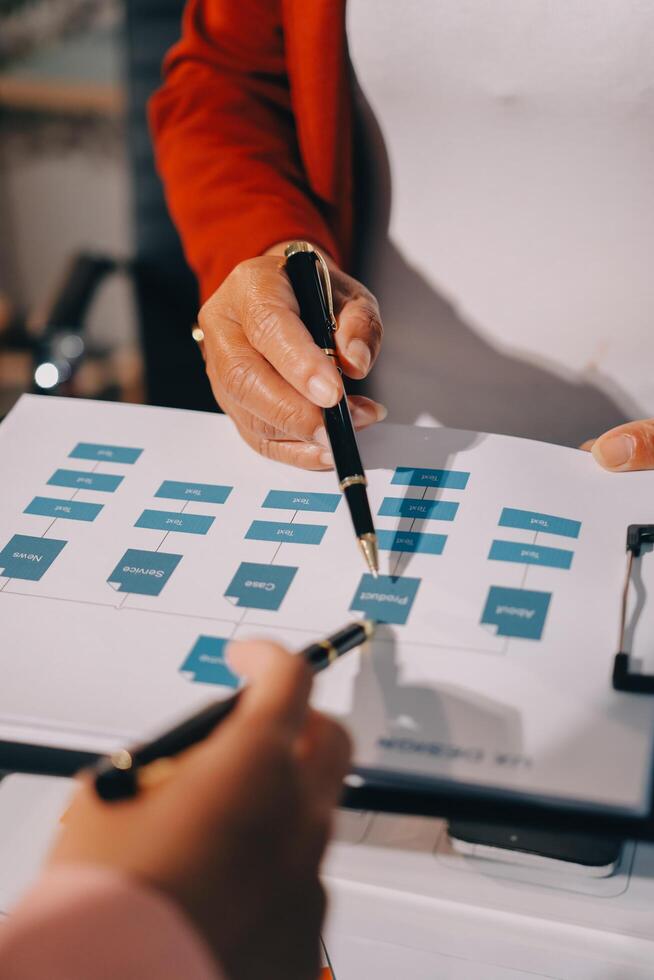 A woman is holding a pen and paper while another person is looking at a document photo