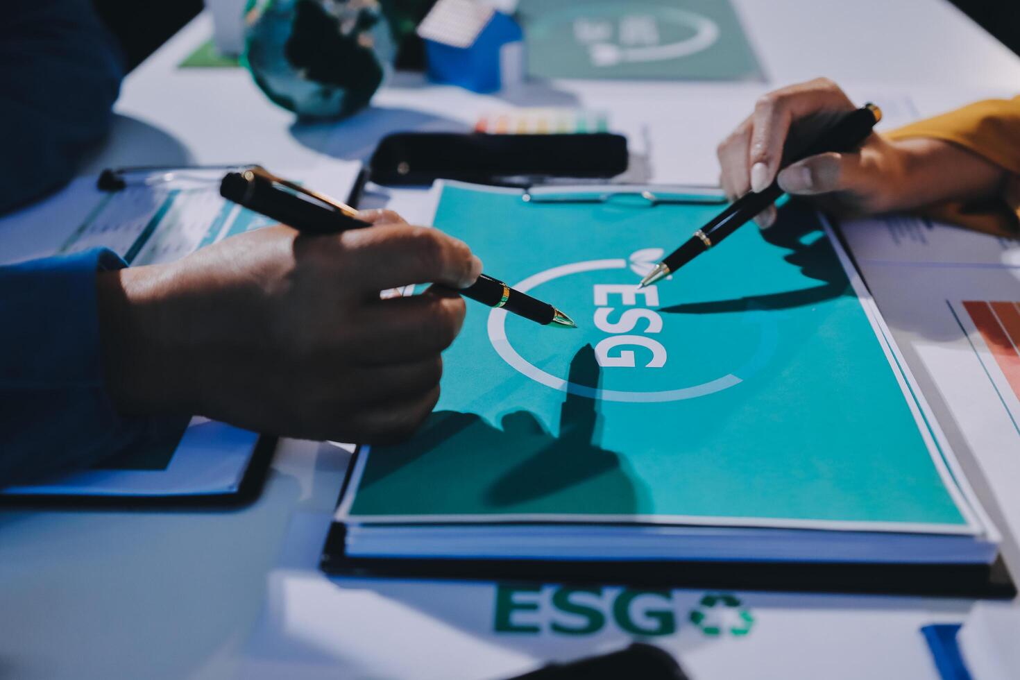 Two people are working on a document with the esg logo photo