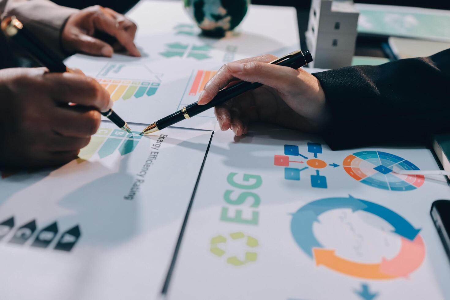Business people working on a table with graphs and papers photo
