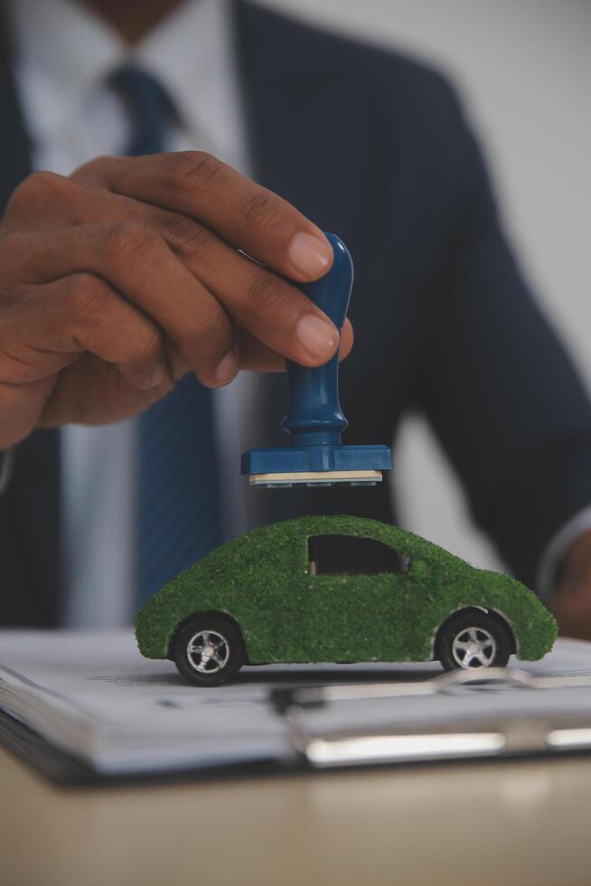 A man in a suit holding a toy car photo