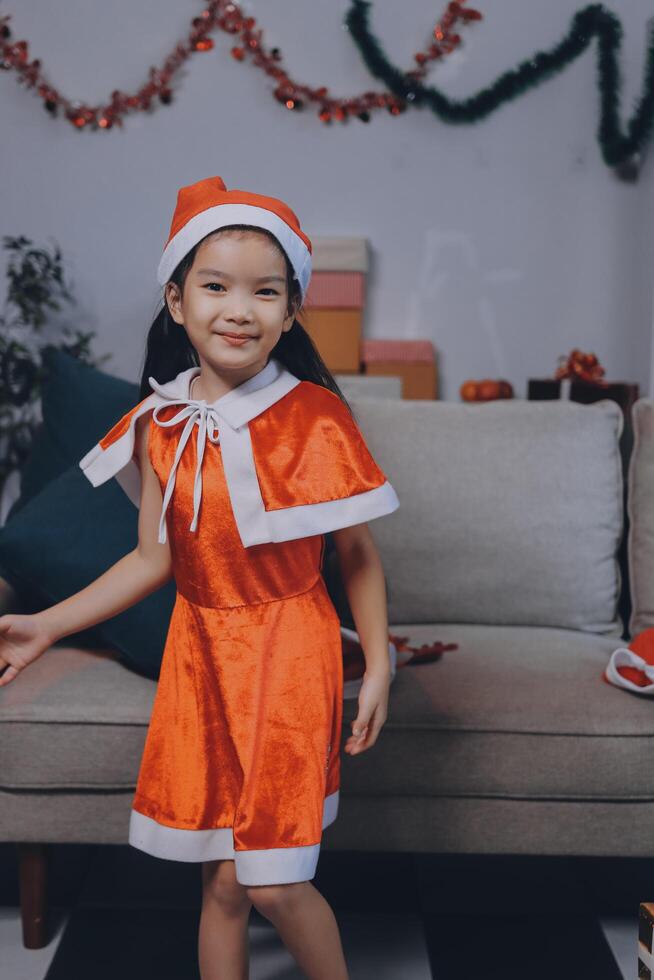 A little girl in an orange santa outfit photo