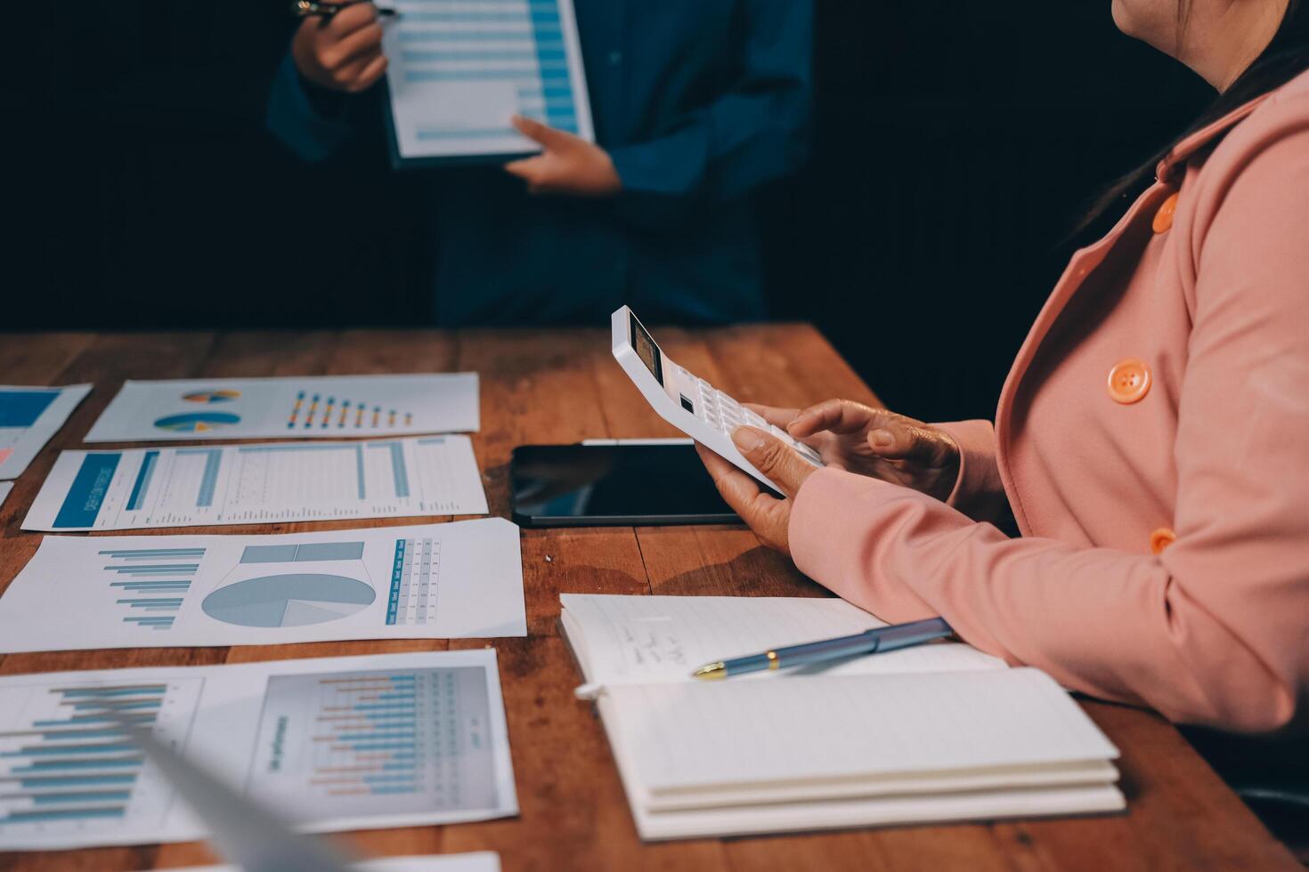 Business people working at a table with papers and graphs photo