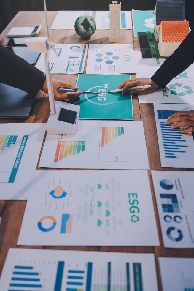 Business people working on a table with graphs and papers photo