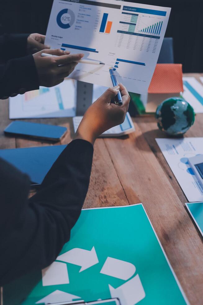 Business people working on a table with papers and graphs photo
