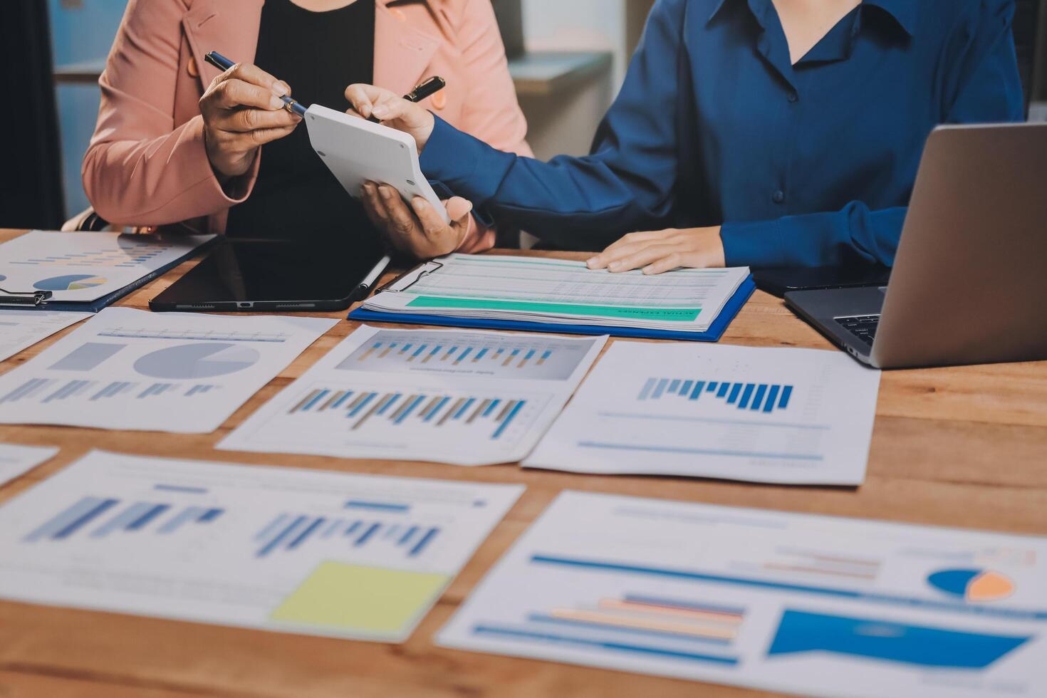 Two business people sitting at a table with papers and graphs photo