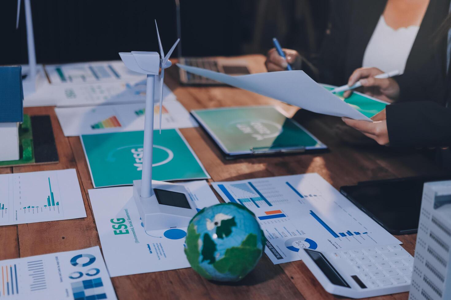 Business people working on a table with papers and graphs photo