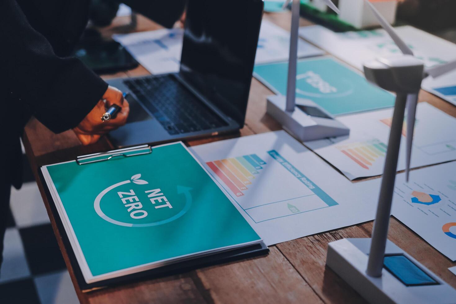 A man is working on a laptop with a green logo on it photo