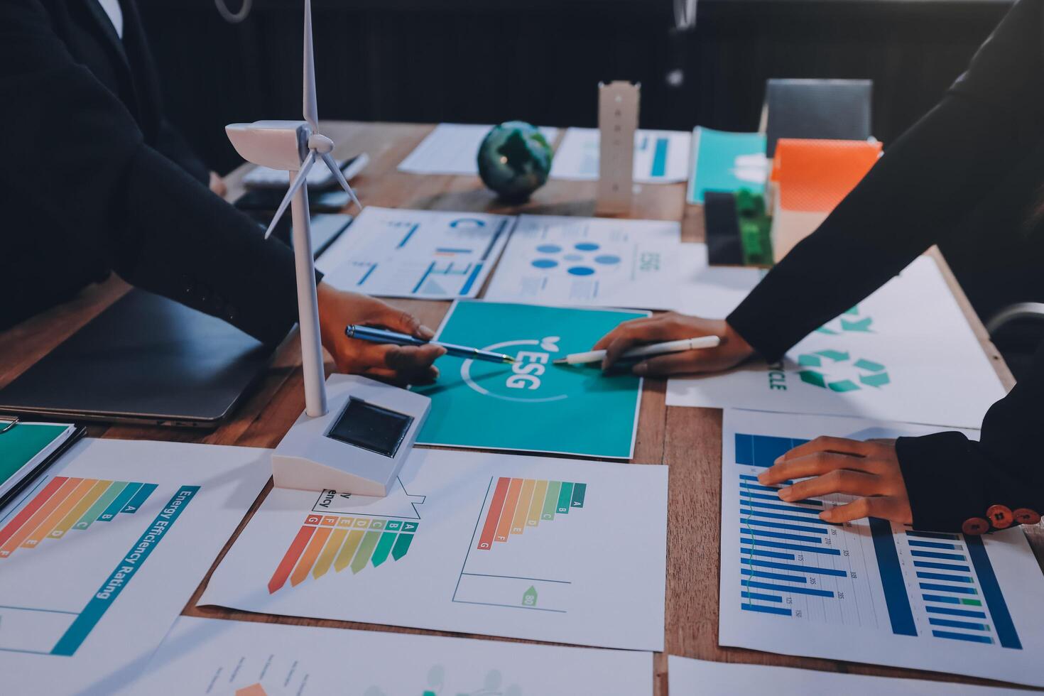 Business people working on a table with graphs and papers photo