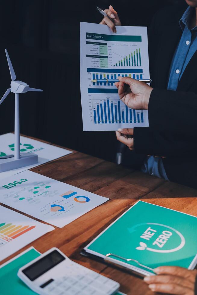 Businessman showing graphs and papers on table photo