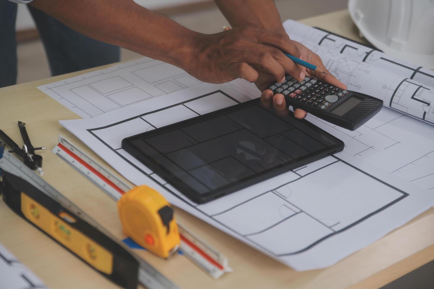 A man using a calculator to calculate the cost of a home renovation photo