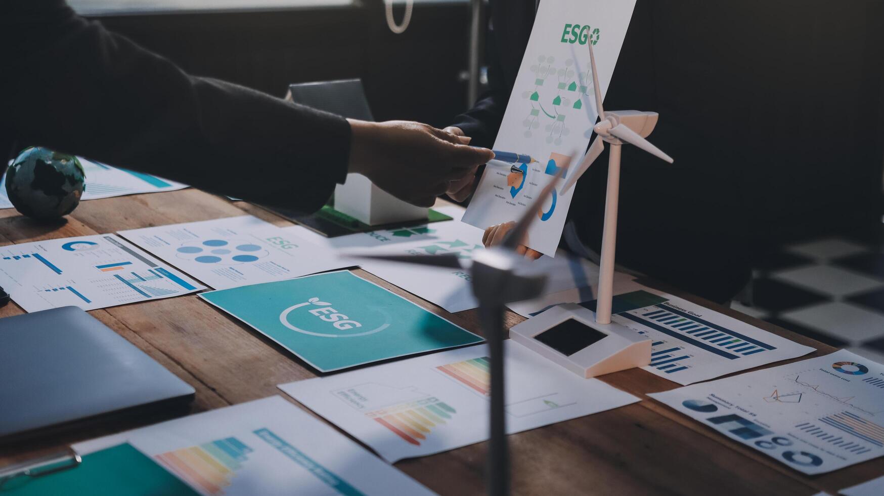 Business people shaking hands over a table with papers and graphs photo