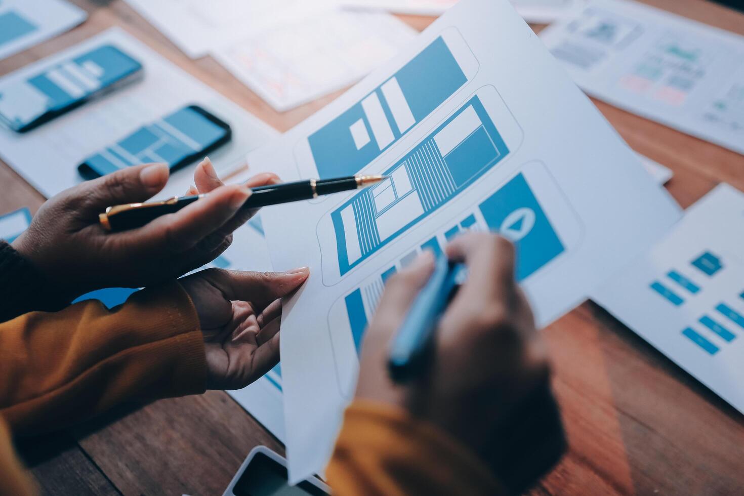 A person is holding a pen and paper while looking at a design photo