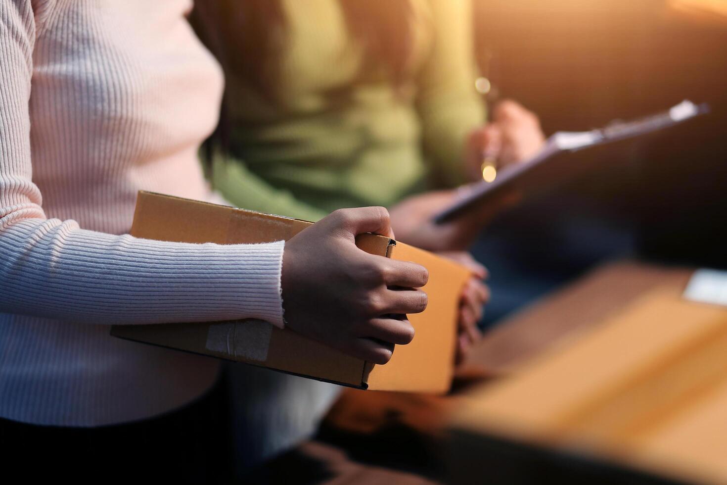A woman holding a box with a pen in her hand photo