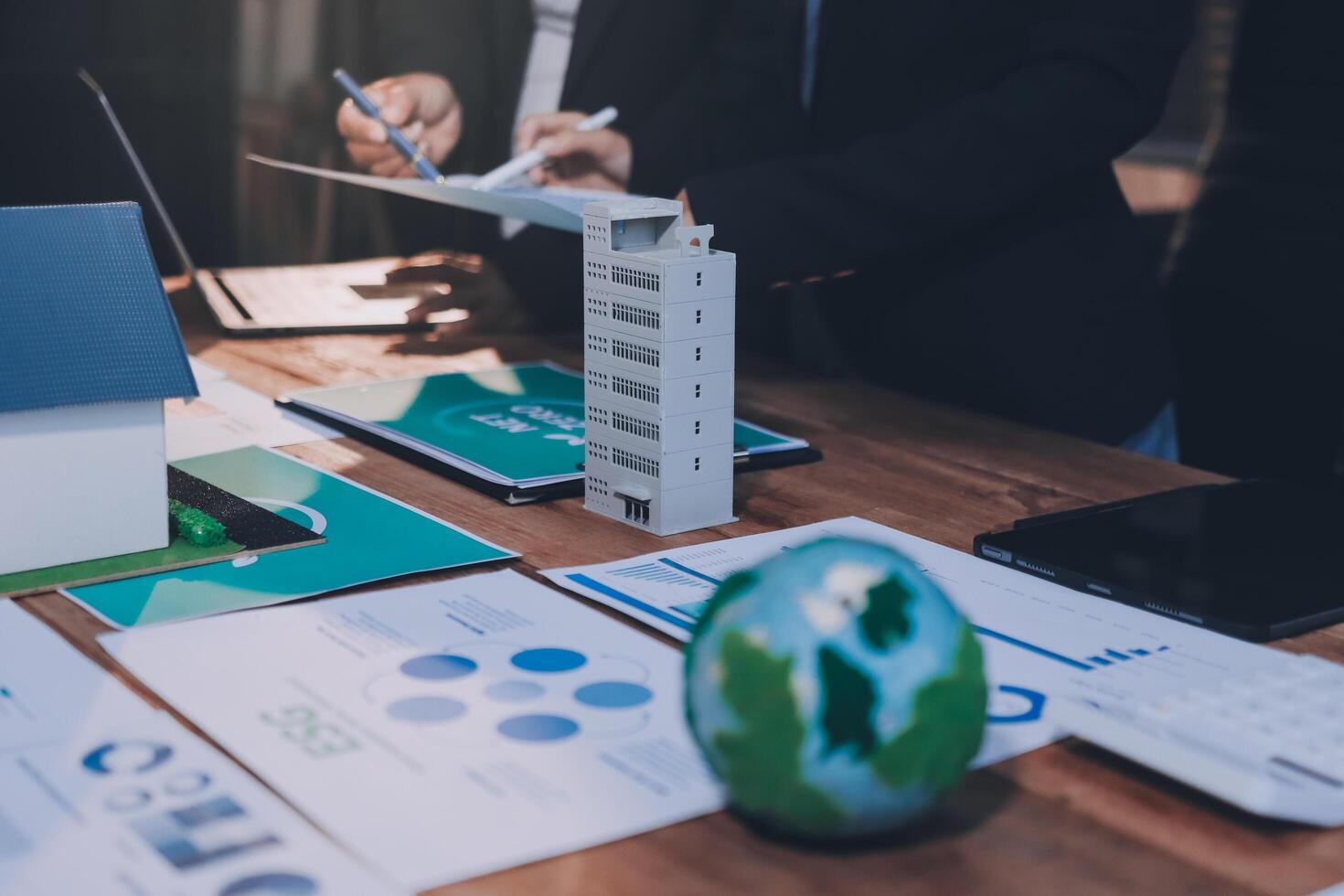 Business people working on a project with a house and a globe photo