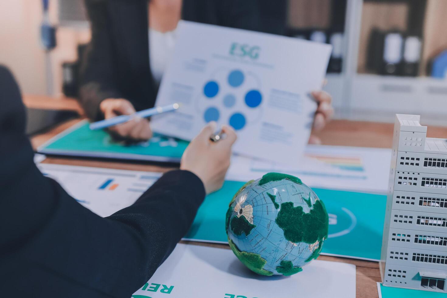 Business people working on a project with a globe and paper photo