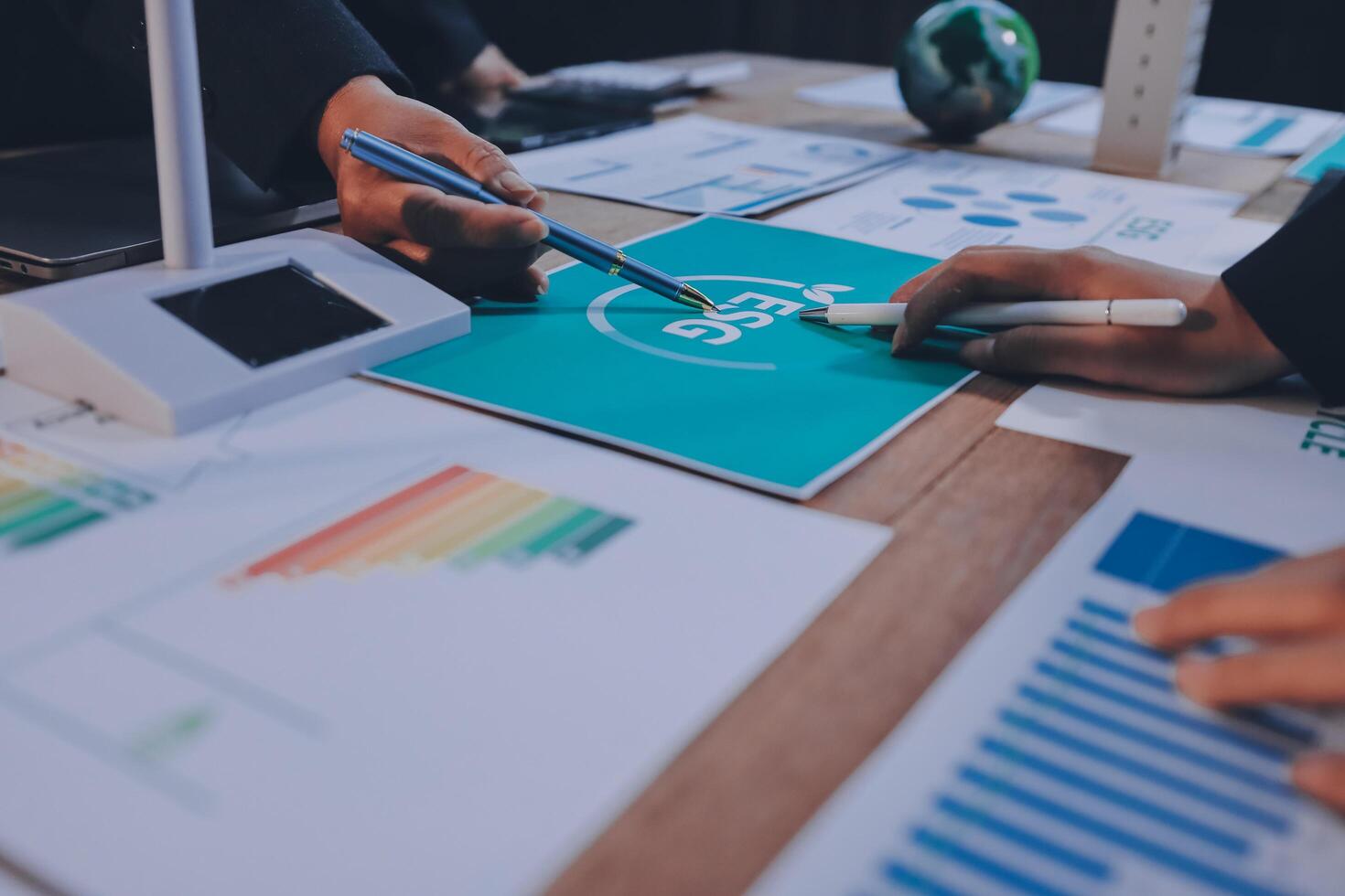 Business people working on a project with graphs and papers photo