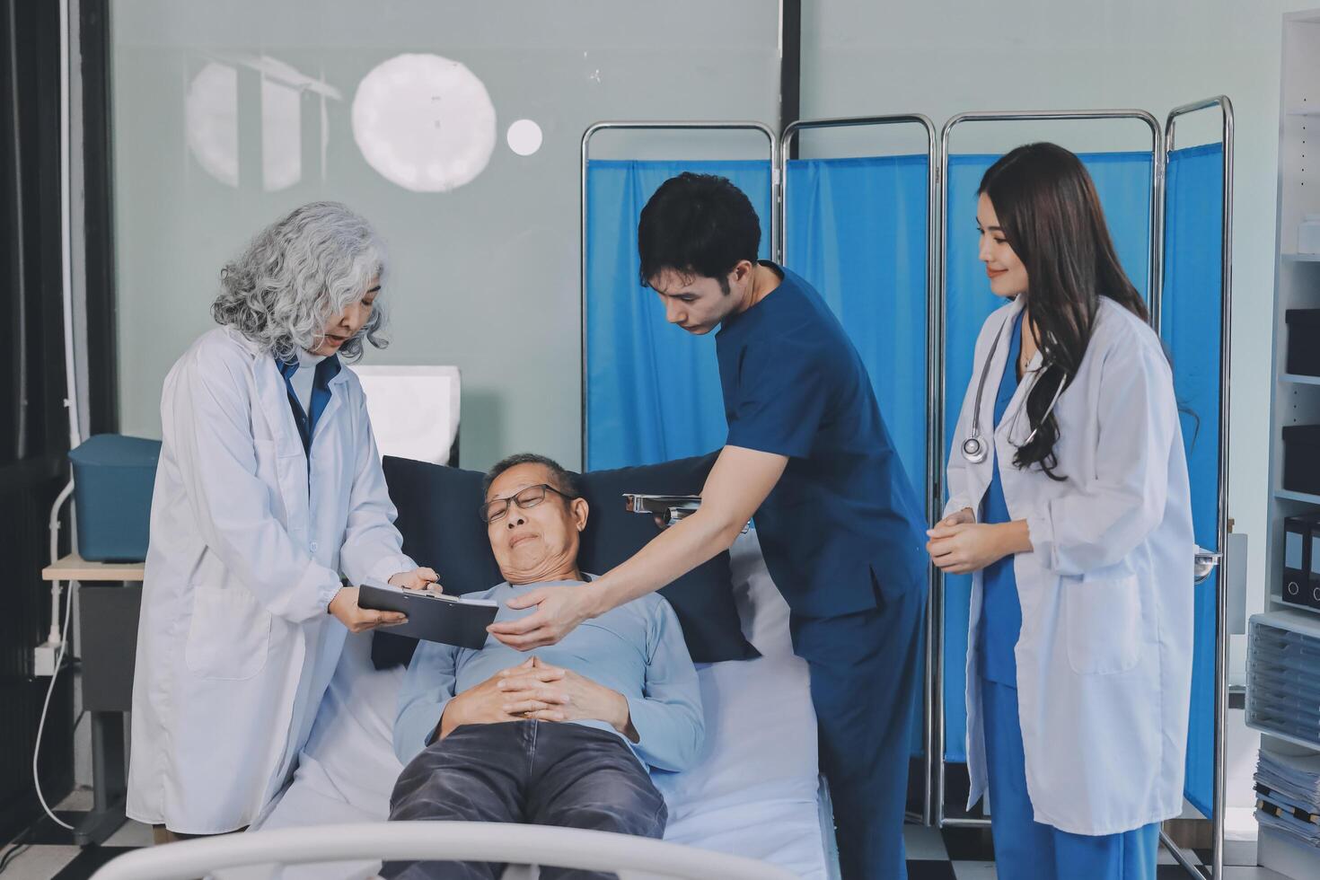 A group of doctors and nurses standing around a patient in a hospital bed photo