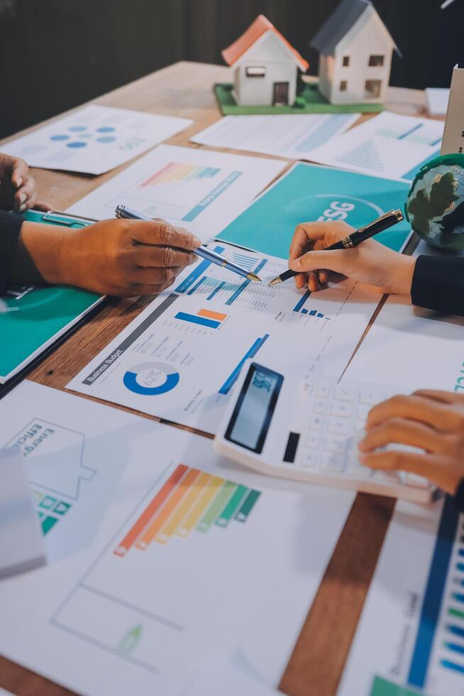 Business people working on a table with papers and graphs photo