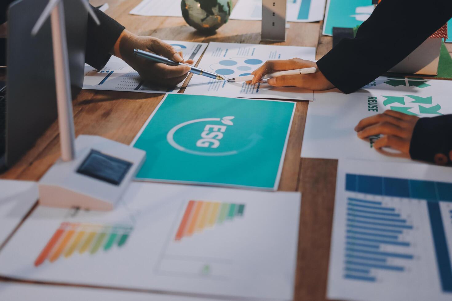 People working on a table with papers and graphs photo