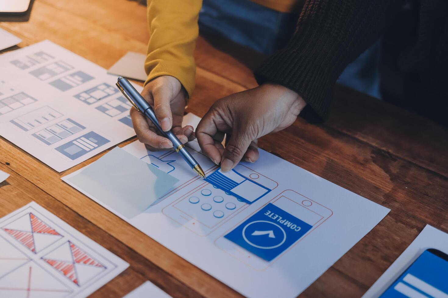 A person is holding a pen and drawing on a paper photo