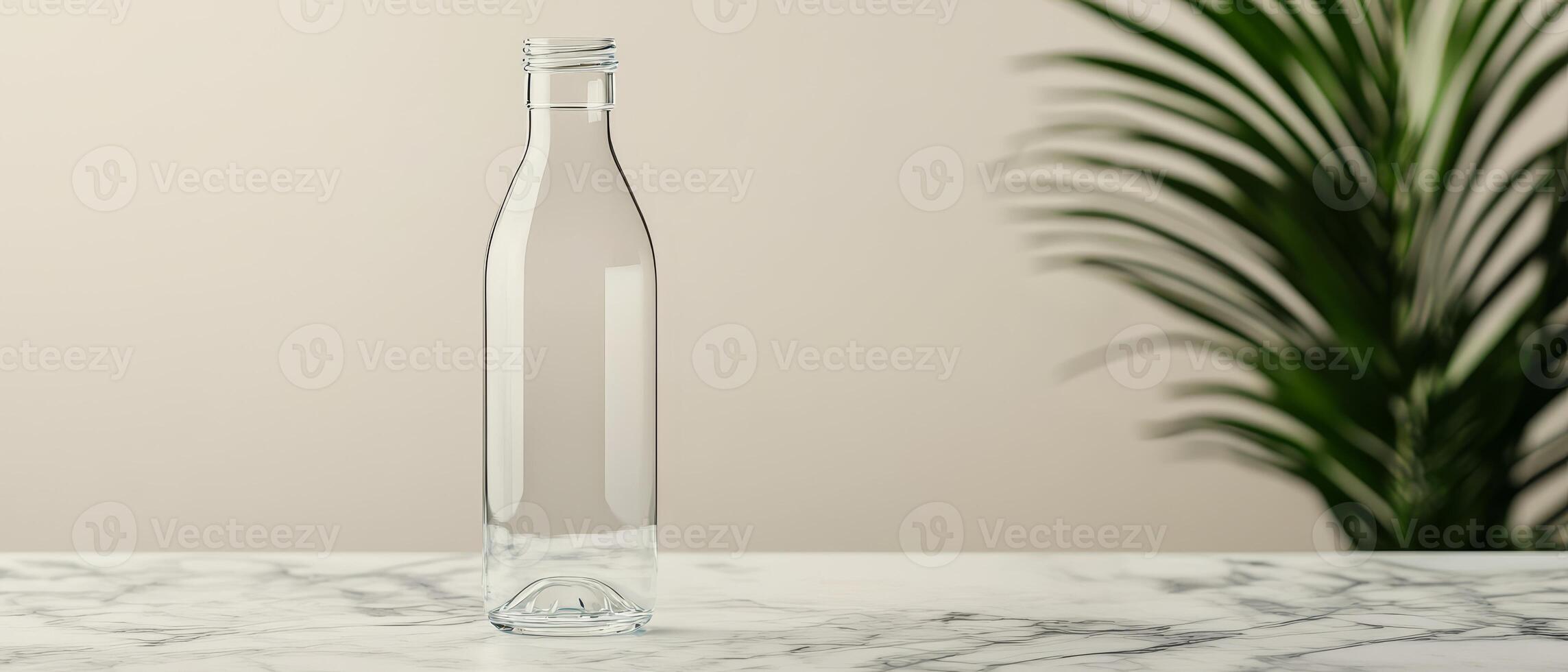 Future lifestyle minimal concept. Empty glass bottle on a marble surface with a plant in the background. photo