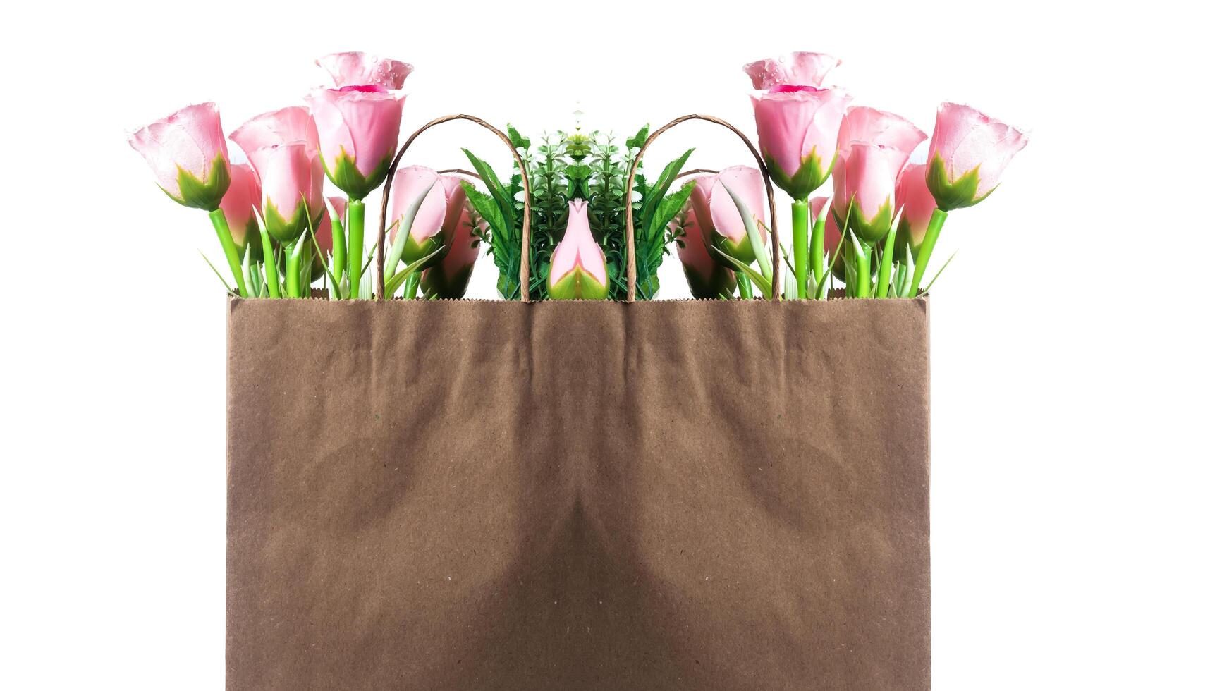Brown paper bag holding bouquets of pink roses on a white background photo
