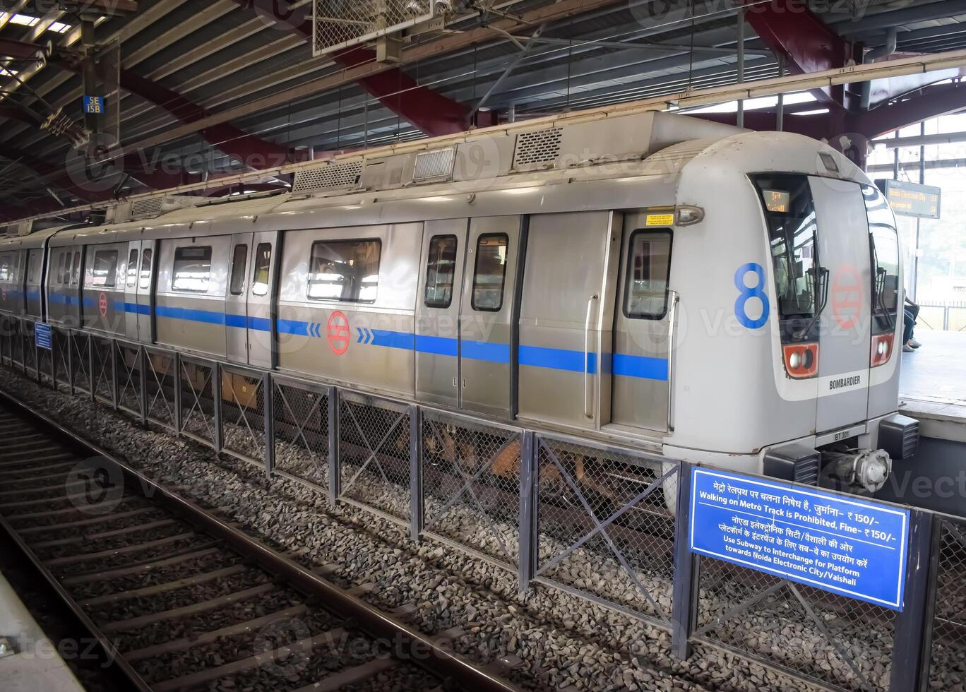 A train is parked at a station with a sign photo
