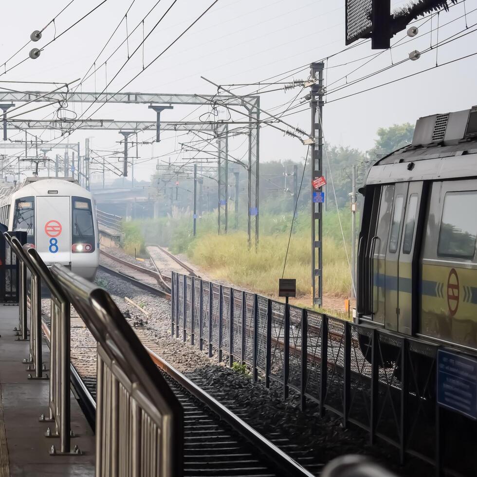 Two trains are on the tracks at a station photo