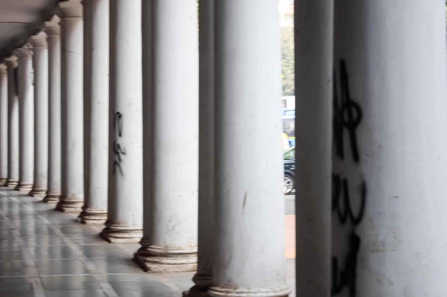 A row of white columns with graffiti on them photo