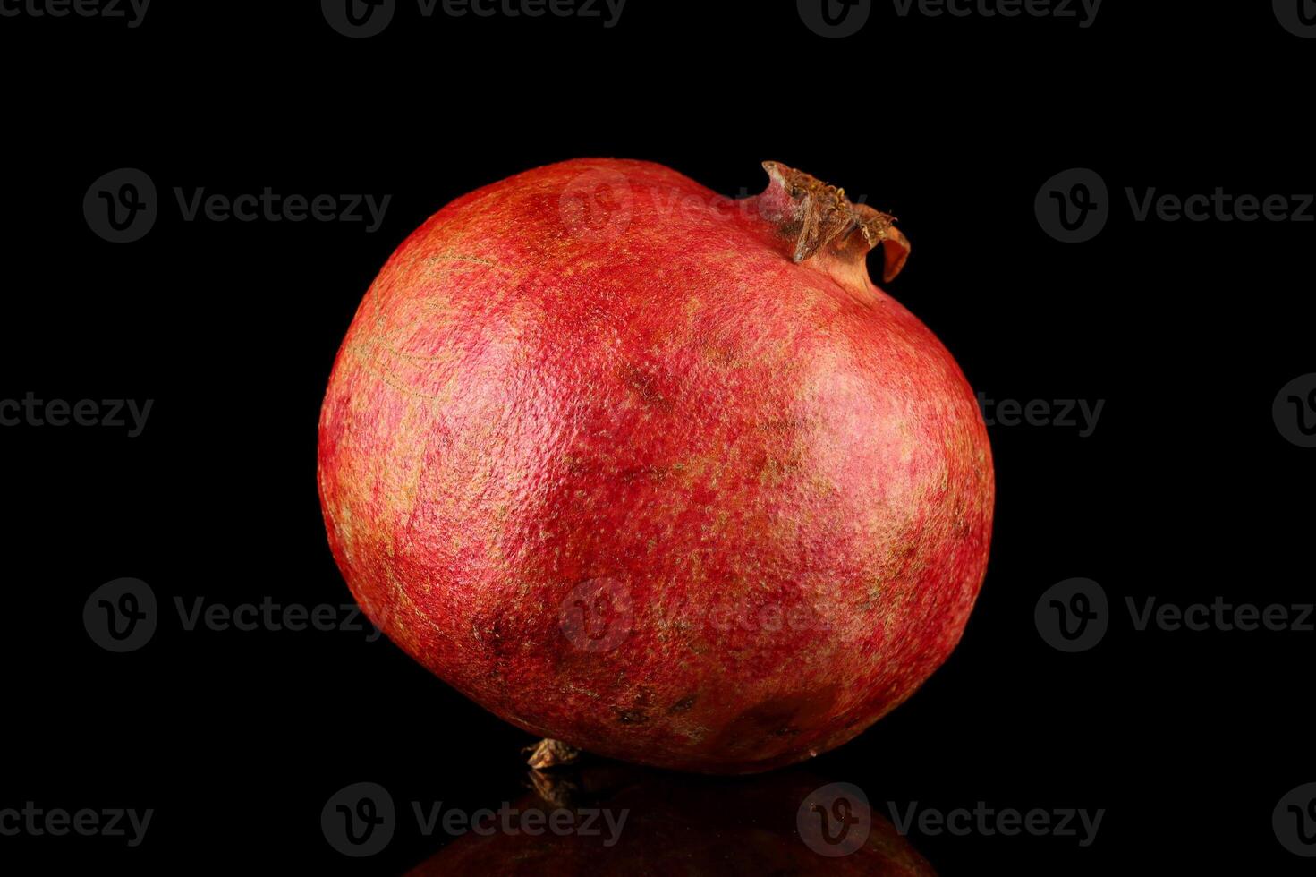 A pomegranate is shown on a black background photo