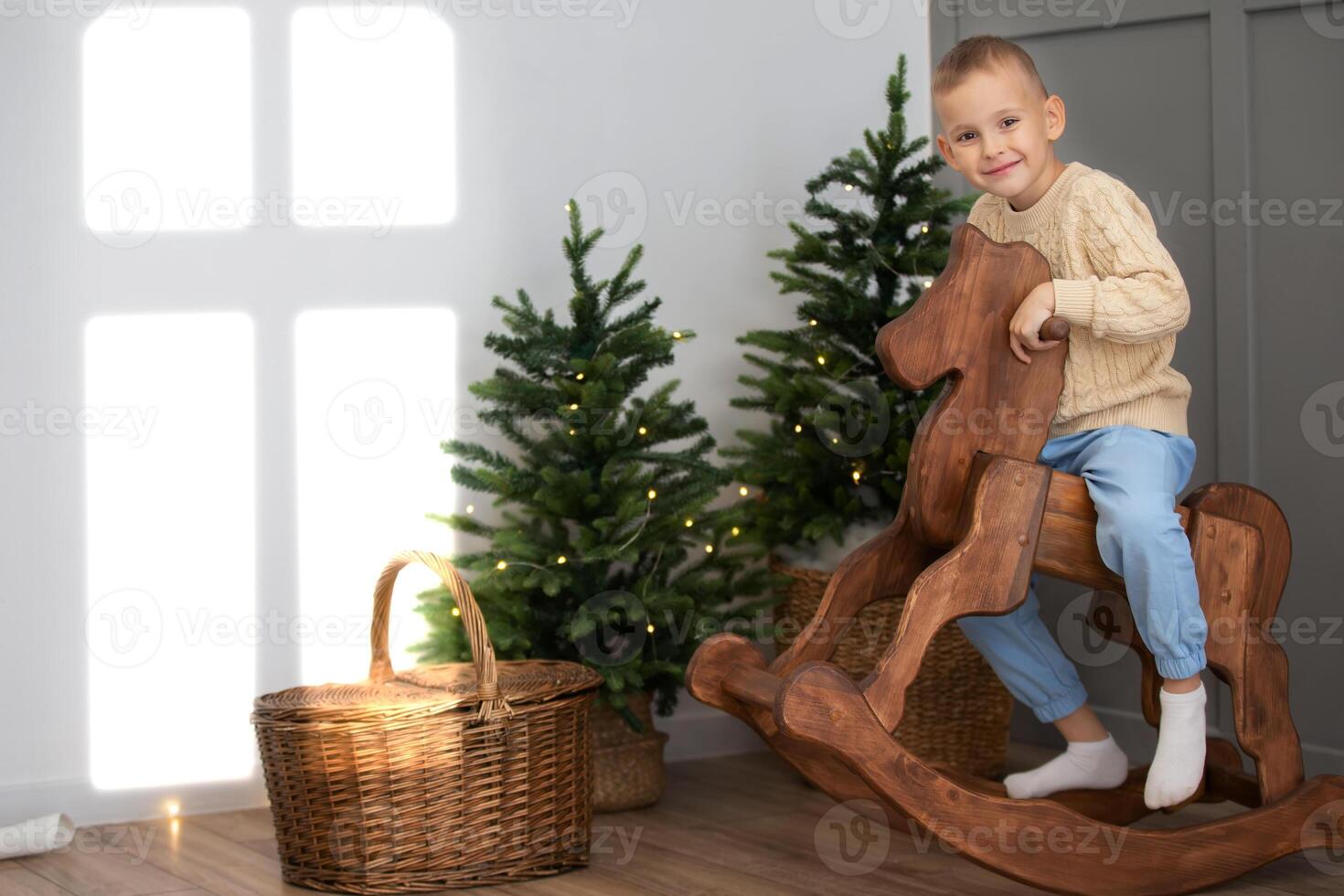 Happy child in the Christmas room playing with a horse gurney. photo