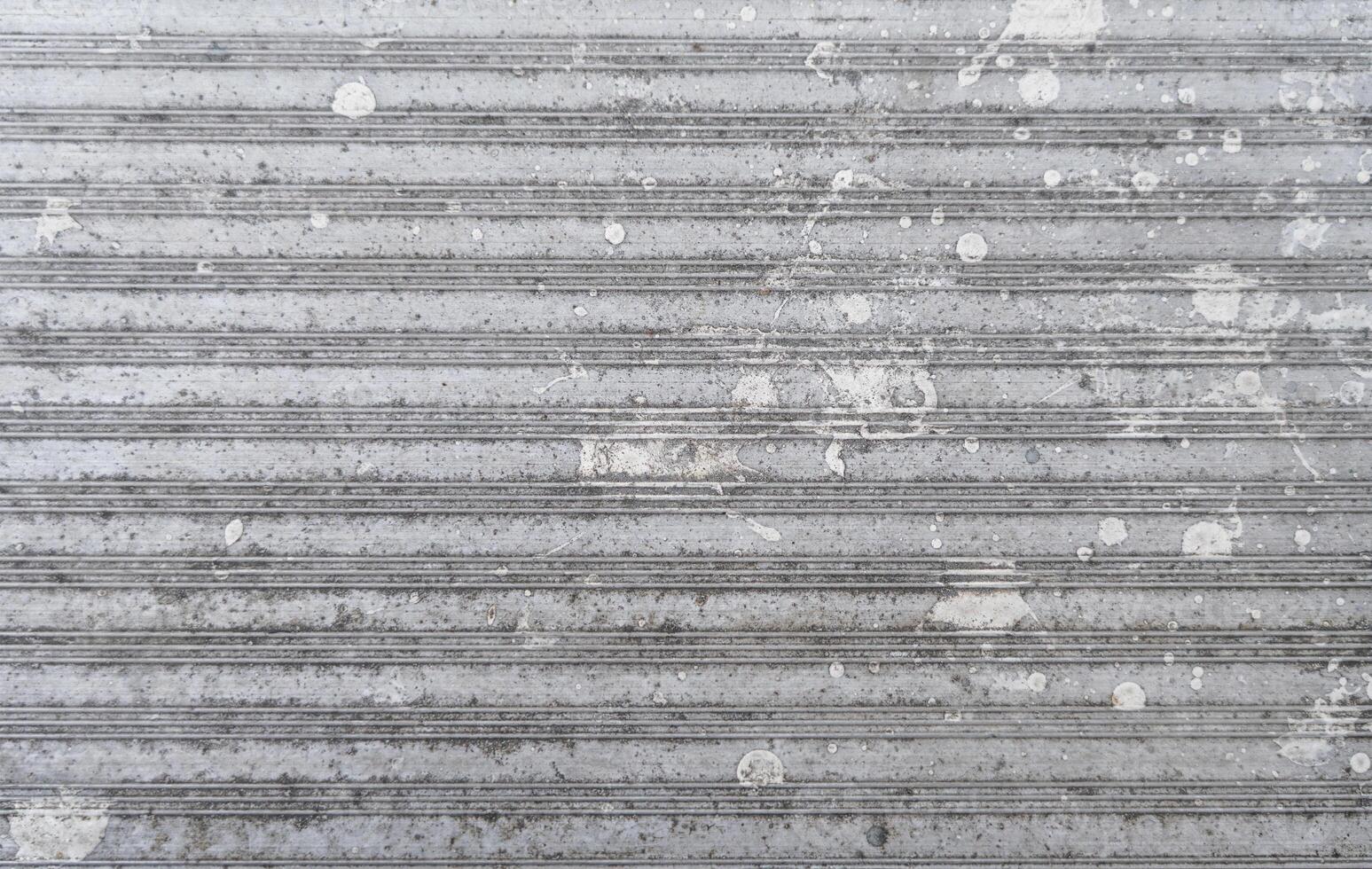Textured metallic surface with stains and grooves. photo