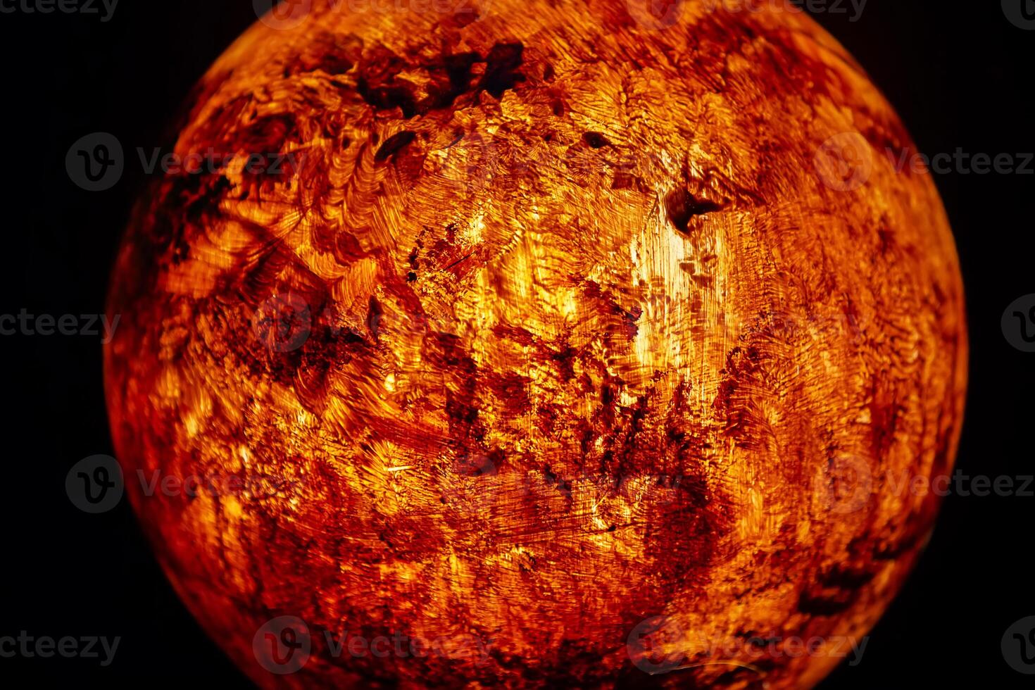 A mock-up of the planet Mars illuminated from the inside on a dark background. photo