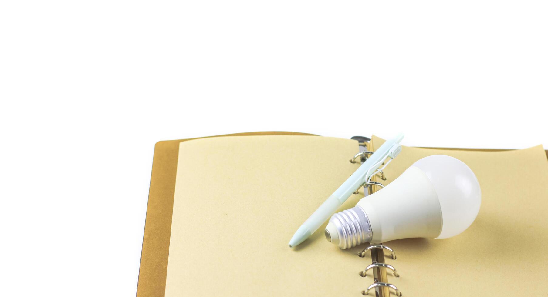 White light bulb on an open notebook, symbol creativity, innovation, inspiration and new ideas. photo