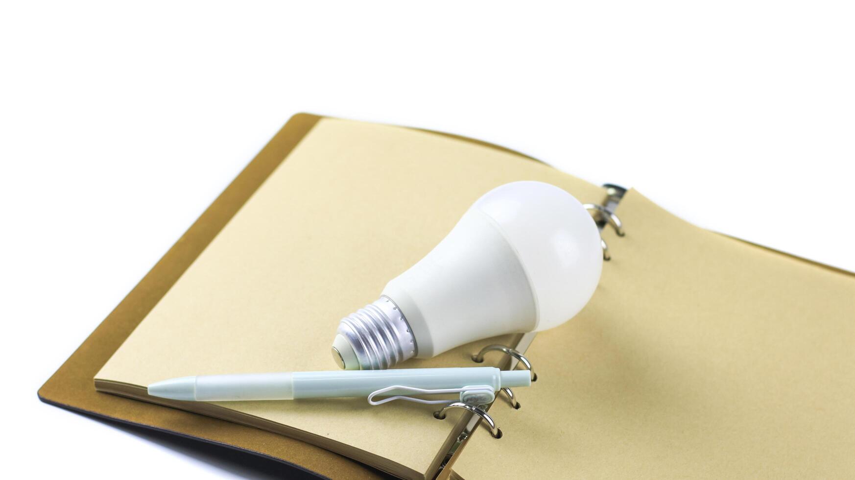 White light bulb on an open notebook, creativity, innovation, inspiration and new ideas. photo