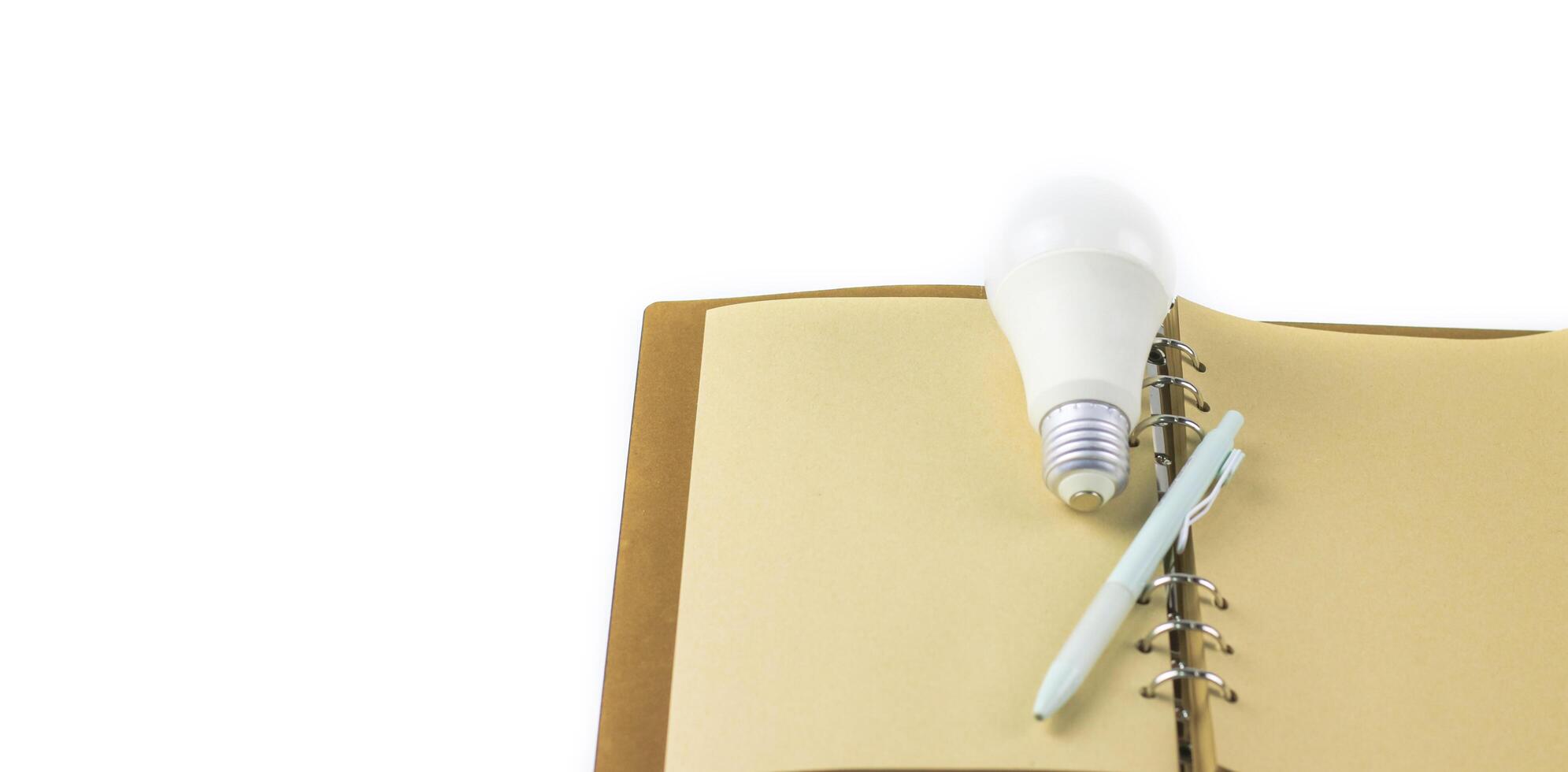 White light bulb on an open notebook, symbolizing creativity, innovation, and new ideas. photo