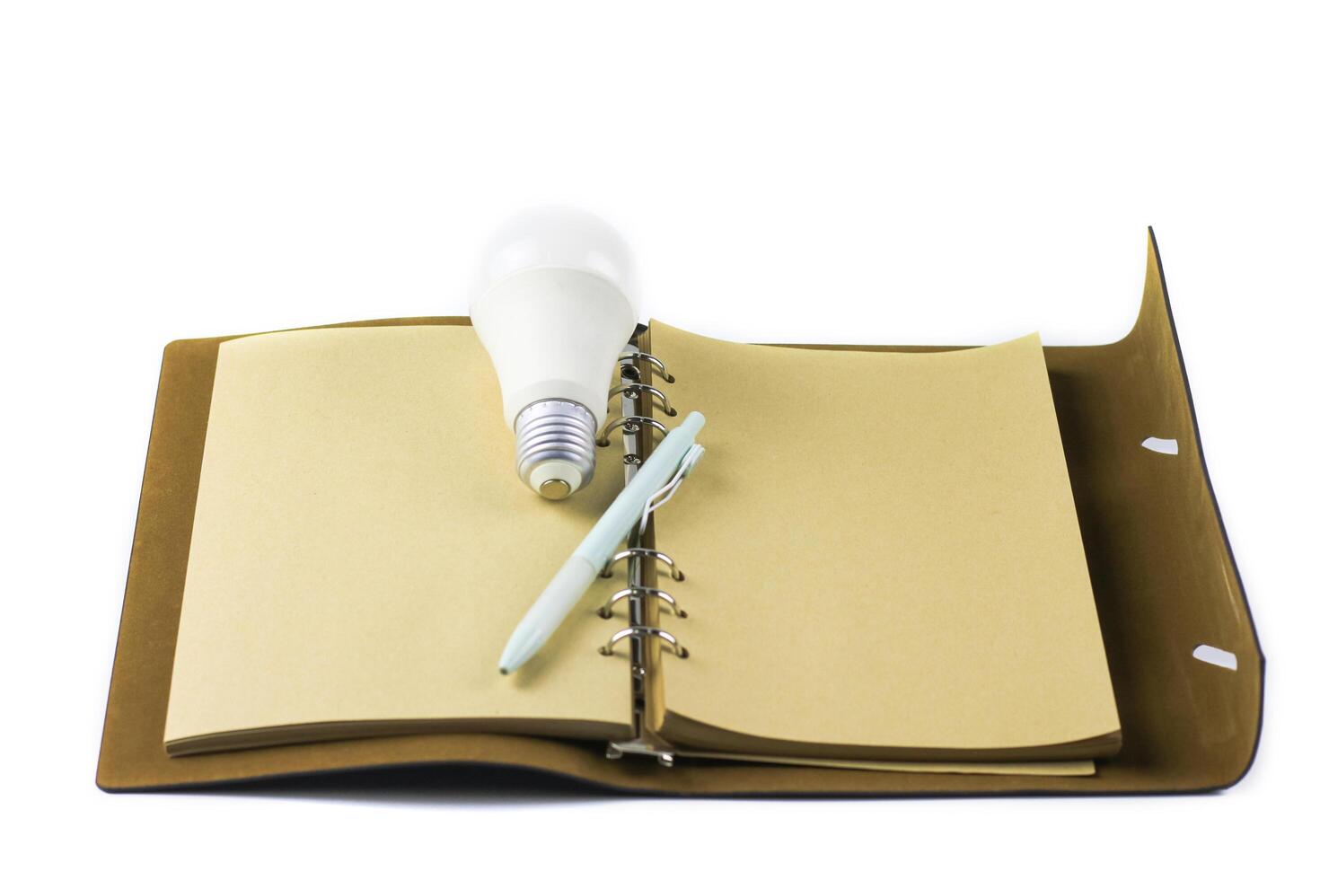 White light bulb on open notebook, symbolizing innovation, inspiration and new ideas. photo