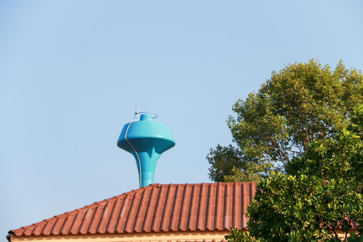 Large blue water supply tank used for distributing clean water to a rural village for daily life, this infrastructure supports sustainable water management and access to safe drinking water. photo