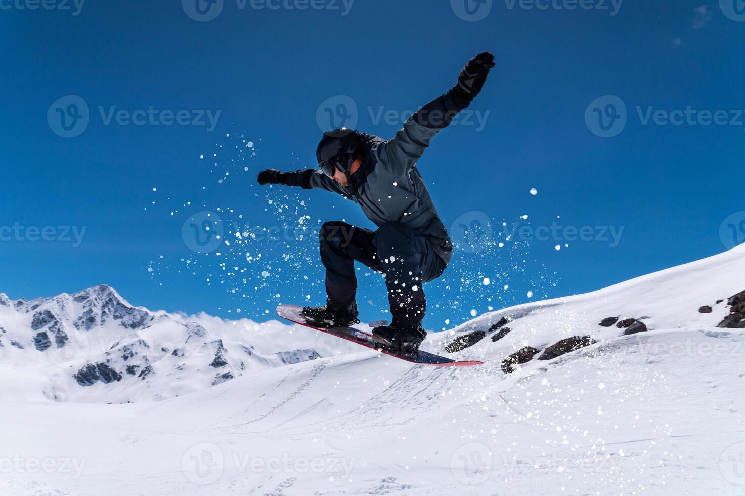 Flying snowboarder in the mountains, extreme sport. Wide angle on the flight in the jump of the snowboarder photo