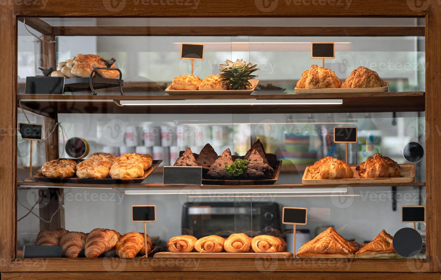 Variety baked bread and dessert in glass showcase at bakery photo