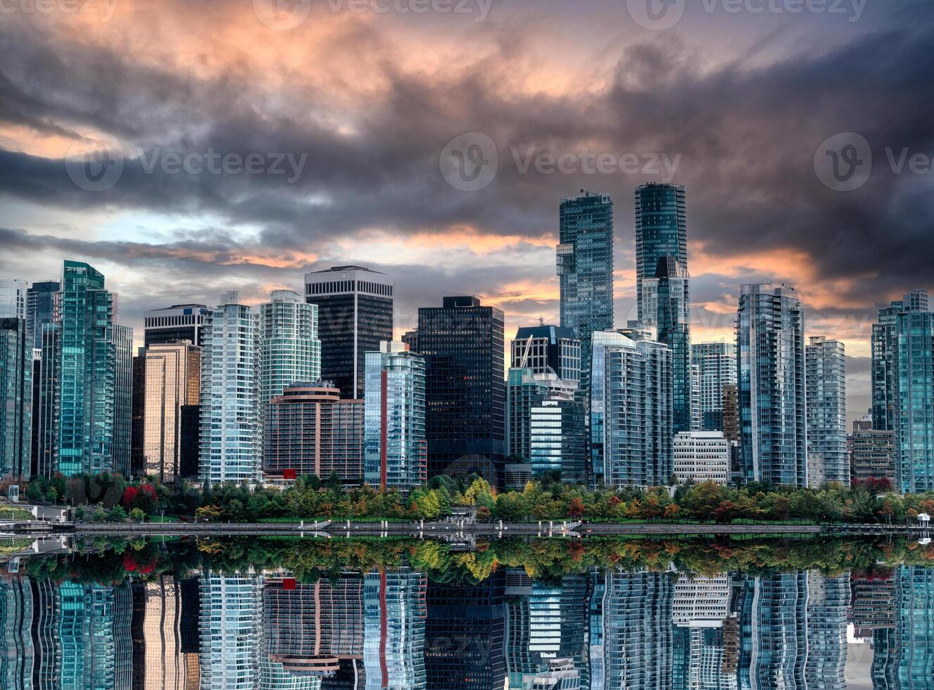 Cityscape of Crowded shiny business buildings reflection on the water in the evening at Stanley Park, Vancouver photo