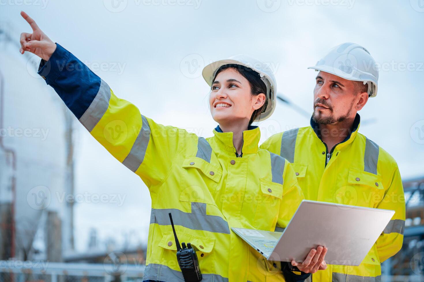 Workers in safety gear collaborate on construction site while assessing project progress photo