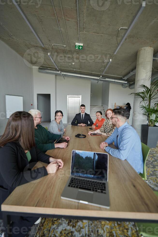 A diverse multiethnic business team engages in a collaborative meeting, discussing strategies and solutions in a modern office setting photo