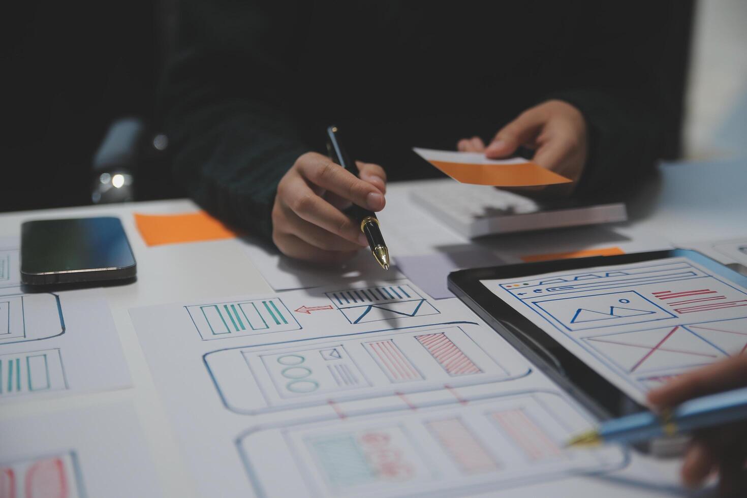 A person is working on a project with a tablet and paper photo